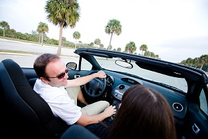 man and woman sitting on front seats of convertible